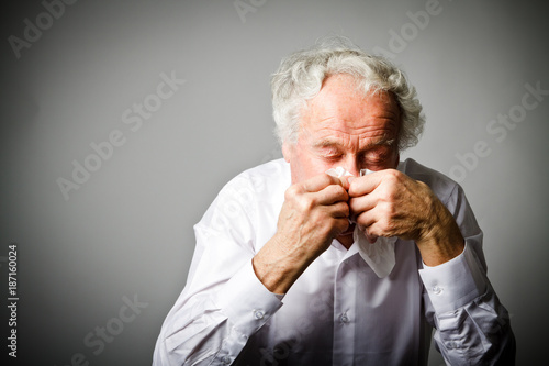 Runny nose. Old man is sneezing.