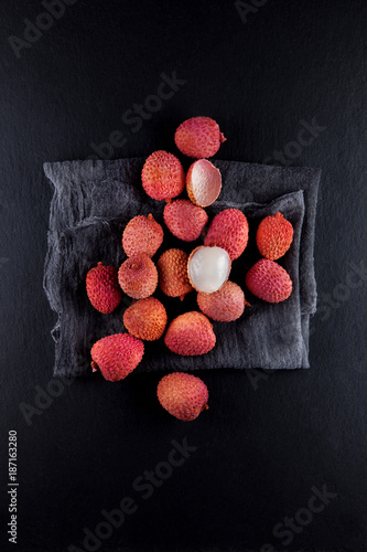 ripe, vermilion exotic lichees decorated on a slate plate kitchen table background with napkin photo