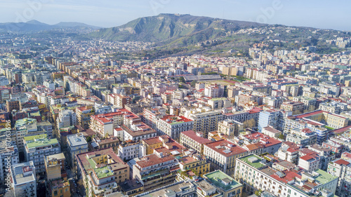 Fototapeta Naklejka Na Ścianę i Meble -  Aerial view of Naples from the Vomero district. The houses and palaces extend in the northern part of the city up to Mount Faito in the background.