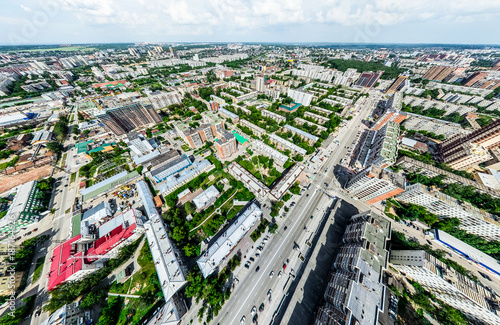 Aerial city view with crossroads and roads, houses, buildings, parks and parking lots, bridges. Helicopter drone shot. Wide Panoramic image.