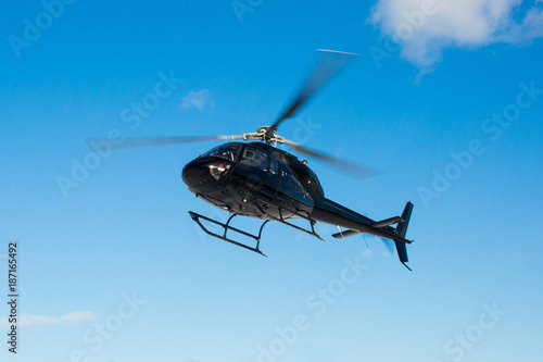 Fototapeta solo black helicopter in blue skies