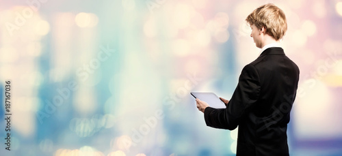 Businessman using a digital tablet on pink and blue abstract light background