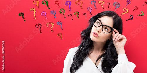Young woman in a thoughtful pose with question marks