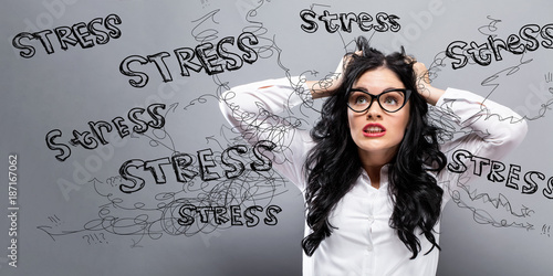 Young woman feeling stressed on a gray background photo