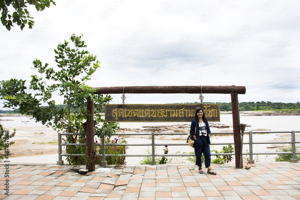 Asian travelers thai woman travel walking and posing take photo at Sam Pan Bok in Mekong river at Ubon Ratchathani, Thailand