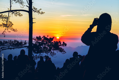 People watching Sunrise in the morning. Tourists travel relax in the holiday. photograph sunrise in the morning among people. Thailand