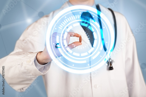 Male doctor holding a pill with glowing circles