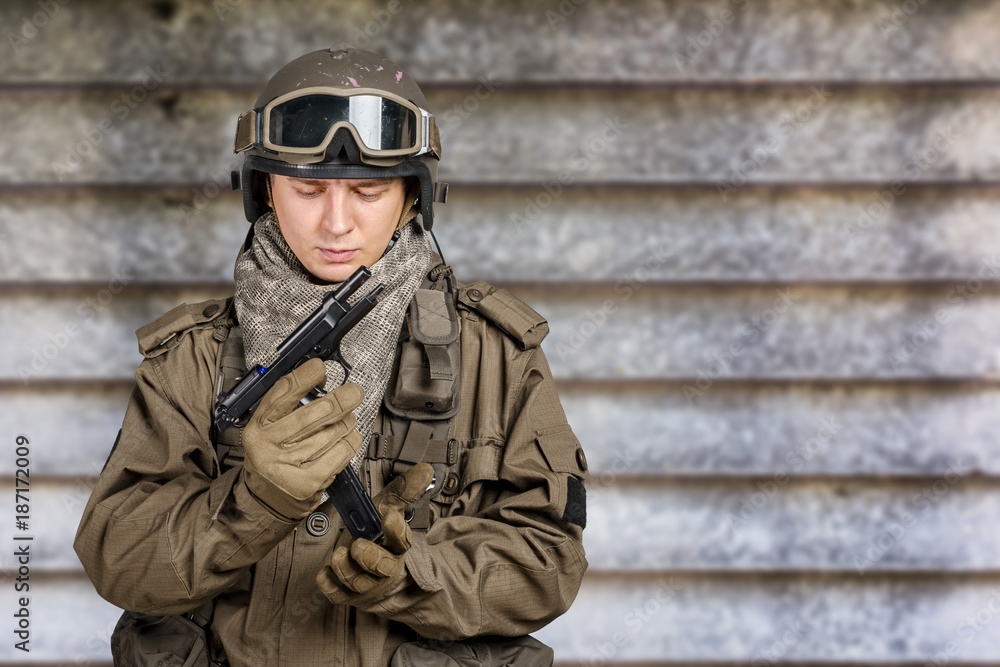 Young man in military uniform checking revolver gun Young man in military uniform checking revolver gun