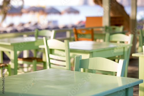 Fototapeta Naklejka Na Ścianę i Meble -  Tables and chairs in a street restaurant in Kamari on Santorini