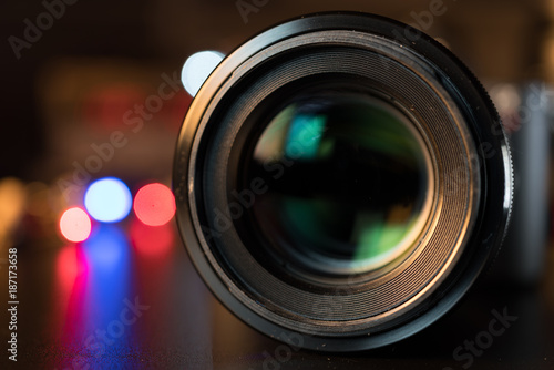 The photo or videocamera lens on dark background with lense reflections