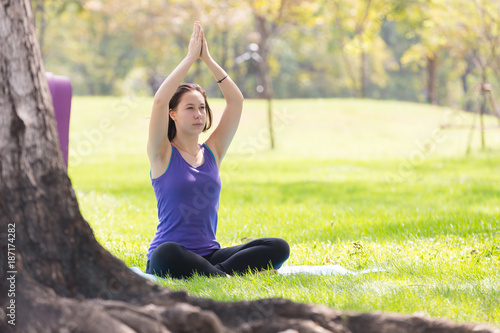 Holiday woman doing yoga pose meditation in the public park Sport Healthy concept. © kasipat