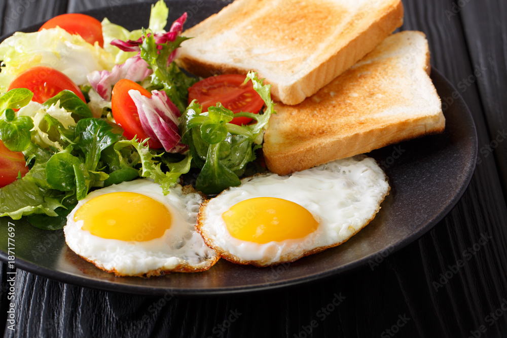 fried eggs with fresh vegetable salad and toast close-up. horizontal fried eggs with fresh vegetable salad and toast close-up. horizontal