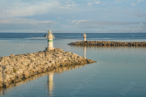 Two small jetty lighthouses at the entrance of a small harbor © Cinar