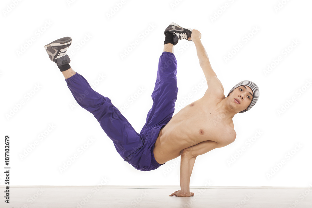 Fototapeta premium Young topless man sitting on one hand in streetdance position holding legs up