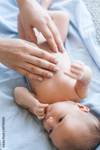 mother does a body massage to a newborn baby. mother s care. healthy lifestyle.