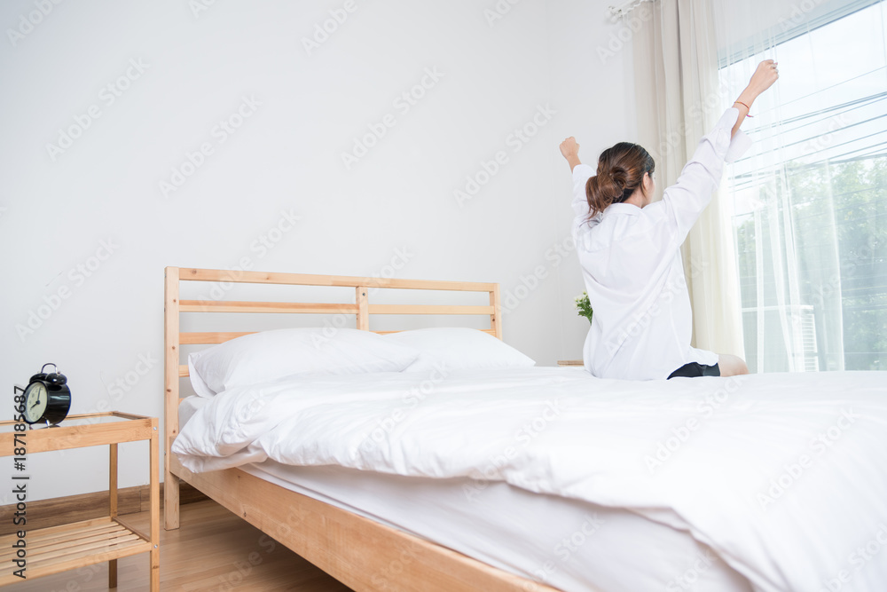 Pretty young woman in bed stretching after wake up Pretty young woman in bed stretching after wake up