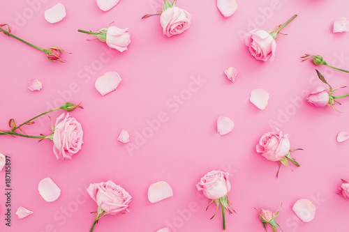 Floral frame made of roses flowers and petals on pink background. Flat lay, Top view. Valentines day background