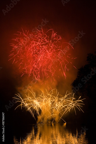 Bright red and yellow fireworks celebrating New year on black background