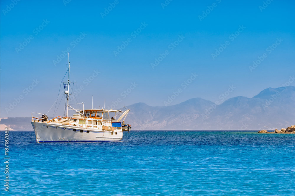weißes Schiff in einer sonnigen, blauen Bucht