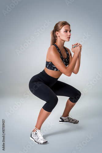 Fitness woman in sports clothing doing sit-ups, studio shot photo