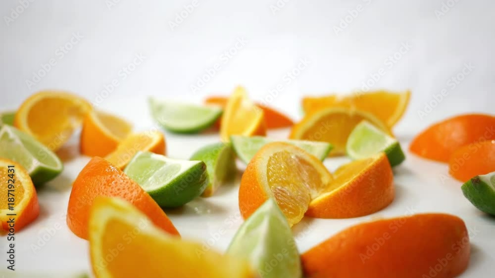 Sliced Orange and Lime wedges spinning over white Sliced Orange and Lime wedges spinning over white