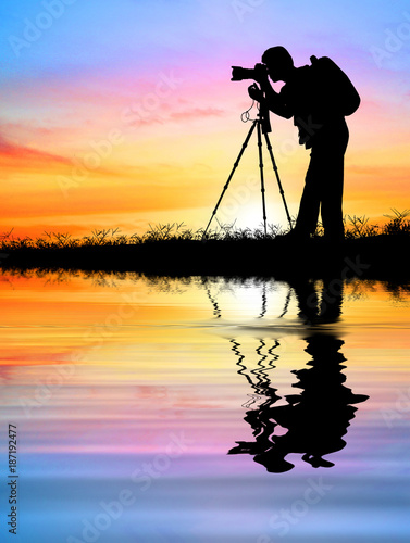 Silhouette of photographer with his camera and water reflection on light pastel background.