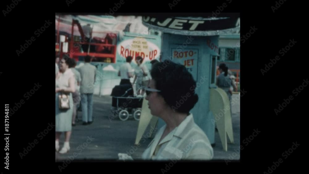 1961 Mother with baby boy in stroller at carnival 1961 Mother with baby boy in stroller at carnival