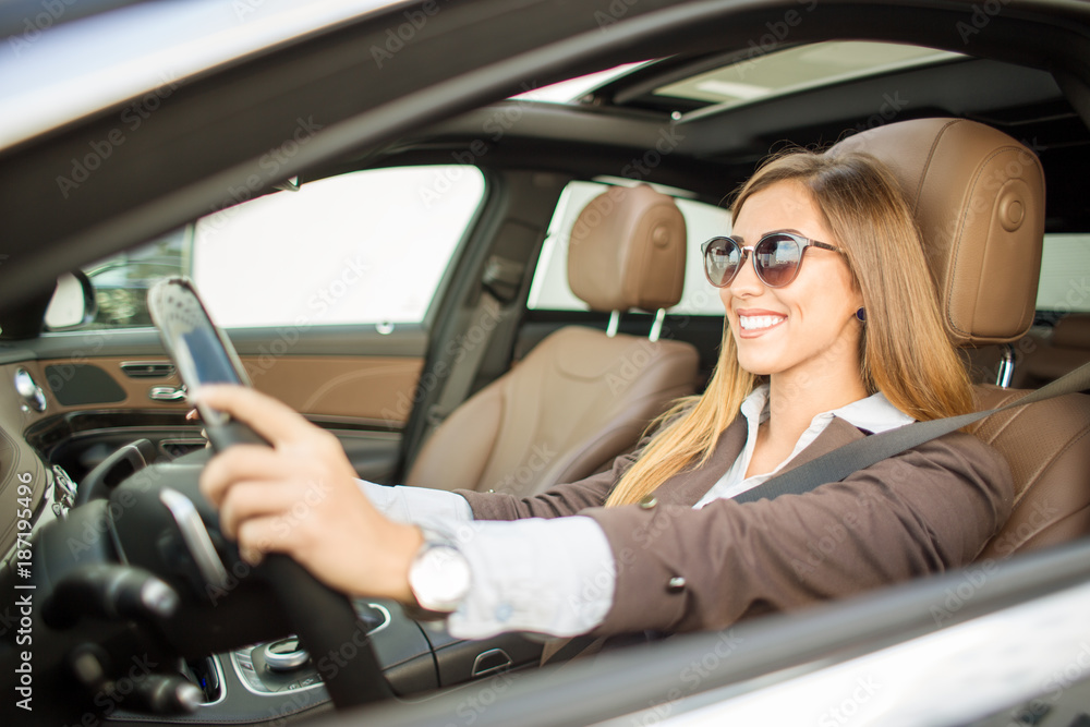 Beautiful businesswoman driving car while smiling Beautiful businesswoman driving car while smiling