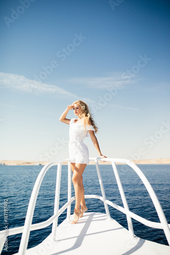 Woman standing on the nose of the yacht at a sunny summer day © F8  \ Suport Ukraine
