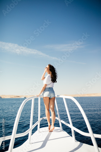 Beauty woman standing on yacht nose on sea background © F8  \ Suport Ukraine
