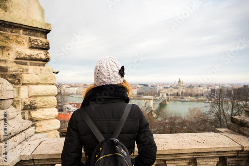 Young woman is admiring the Chain Bridge and Budapest Parliament Building from Fisherman Bastion in BudaPest, Hungary.