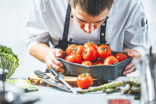 Chefkoch in der Küche mit Frischem Gemüse(Tomaten)
