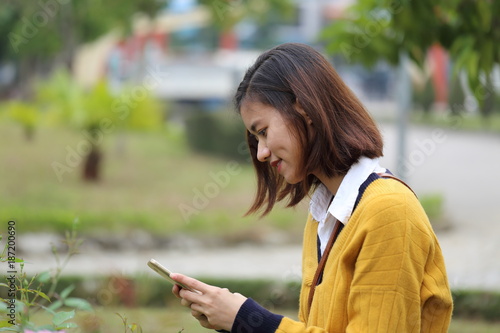 スマートフォンで花の写真を撮影する女性