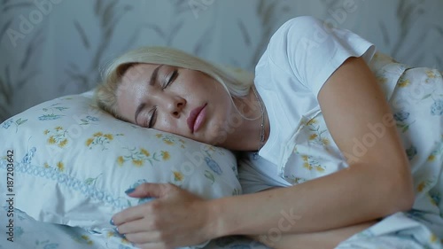 White woman sleeping on the bed and fixing her pillow. Getting pleasure from swwt sleeping. photo