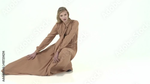 Fashion model in flying beige dress. Slow motion photo