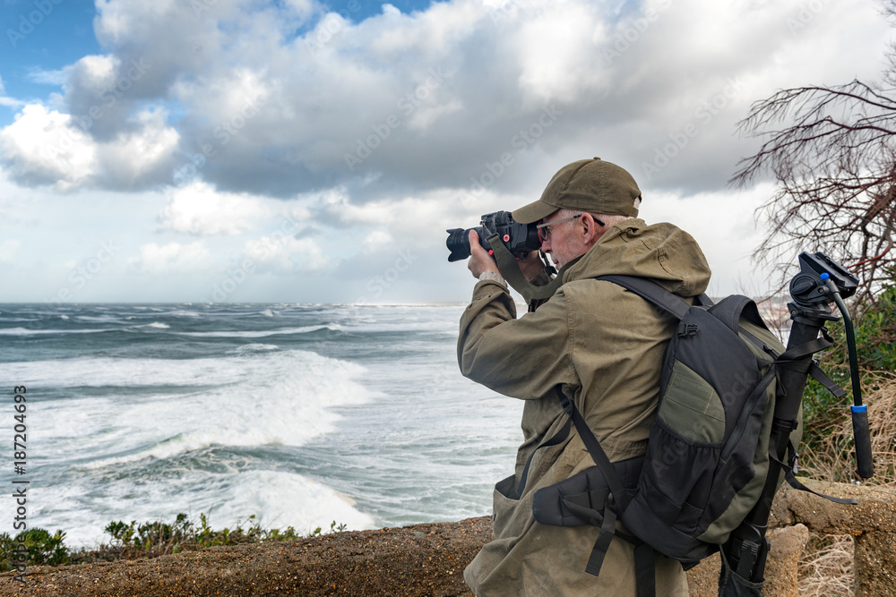 man photographer working during a storm in Biarritz France