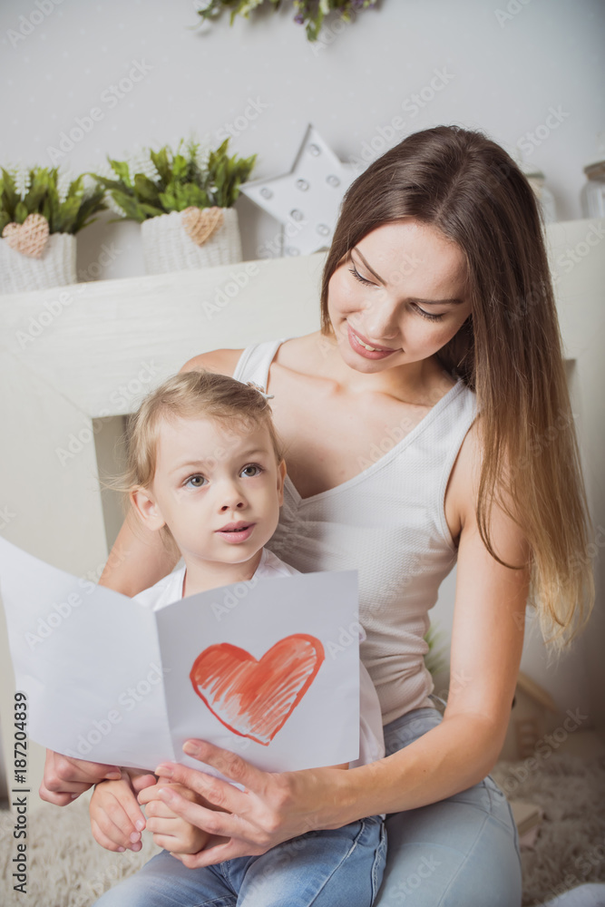 mother and daughter with a card in hand mother and daughter with a card in hand