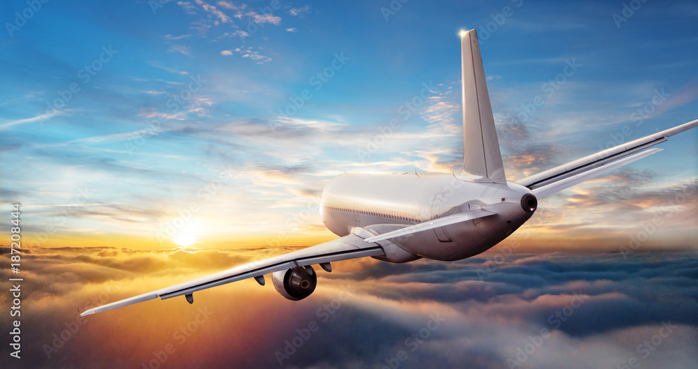 Naklejka premium Odrzutowiec samolotu komercyjnego latające nad chmurami w pięknym świetle słońca.
