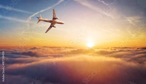 Komercyjny samolot odrzutowy lata nad chmury w pięknym zmierzchu świetle.