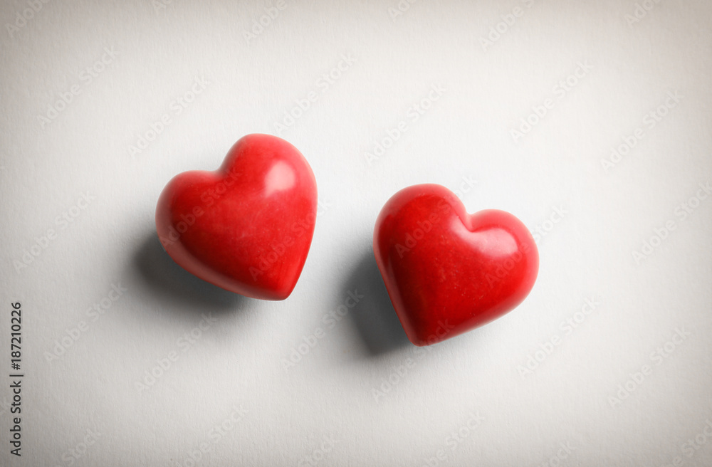 Two red hearts on light background
