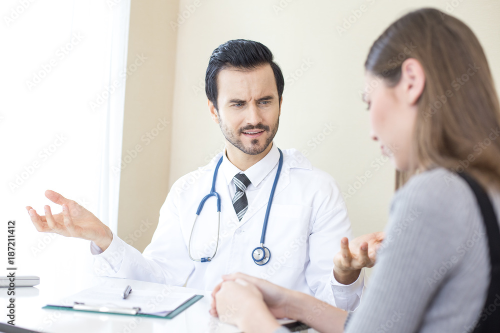 Attractive Doctor working at hospital. Doctor looking to woman with serious emotion. Attractive Doctor working at hospital. Doctor looking to woman with serious emotion.