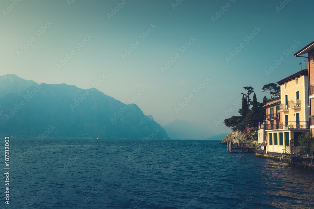 Amazing panoramic view of the lake Garda, with its bright colored houses and the Alps in the background in Malcesine, Northern Italy. Retro vintage toned, cinematic style
