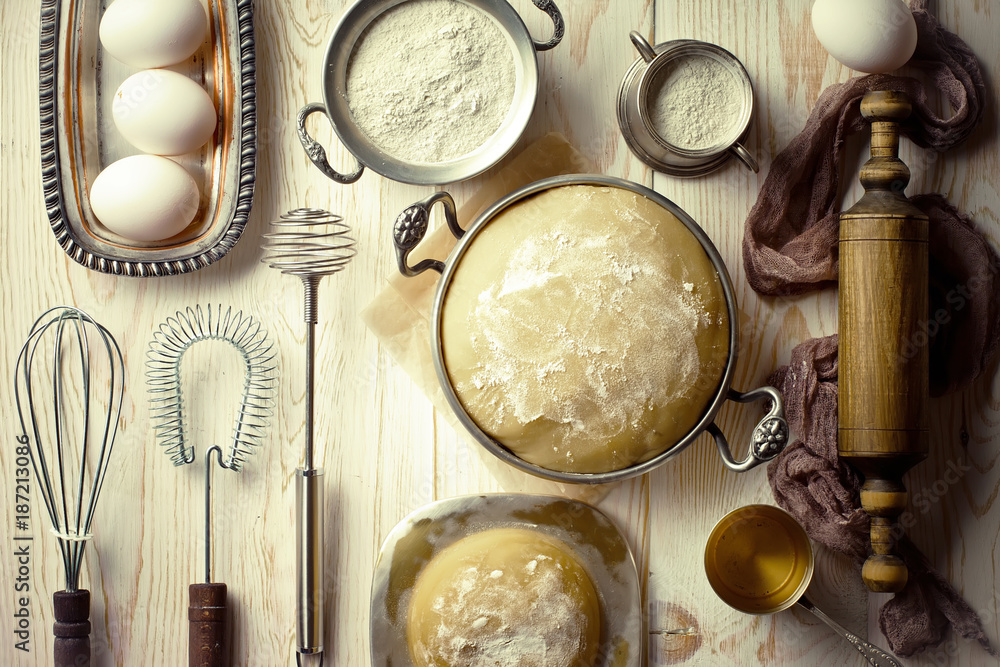 Dough with flour on an old background in a composition with kitchen accessories Dough with flour on an old background in a composition with kitchen accessories