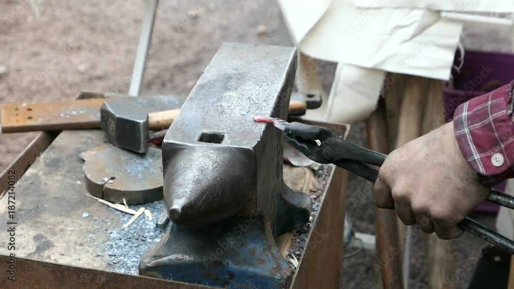 smith hammering metal part on a anvil smith hammering metal part on a anvil