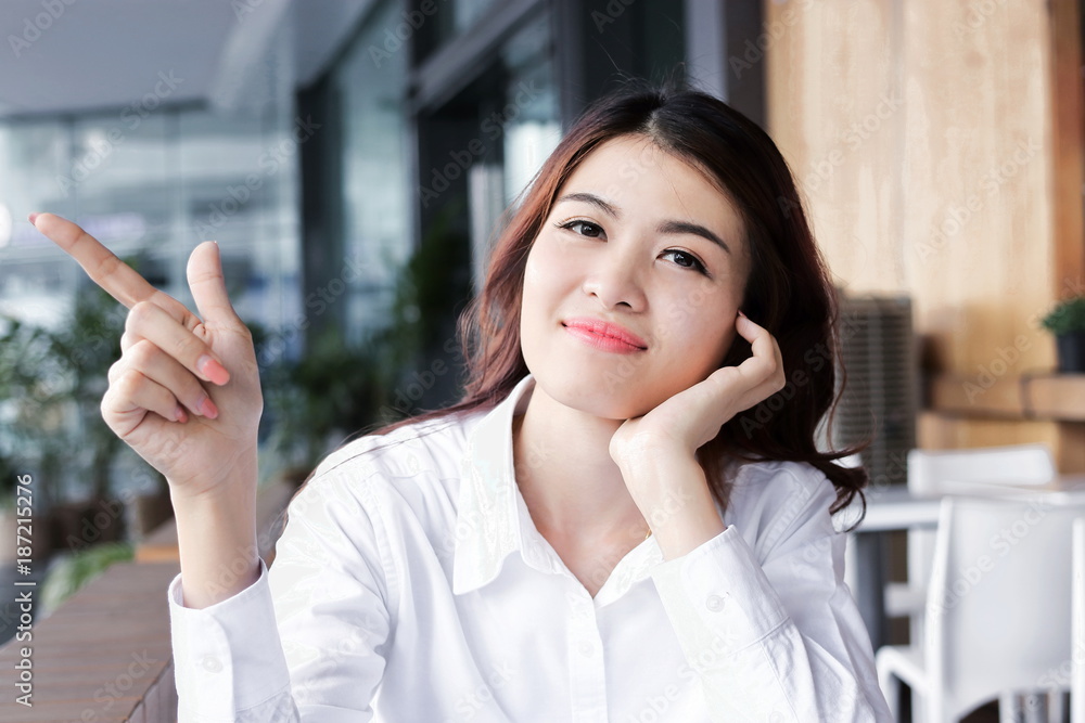 Portrait of attractive young Asian woman looking forward posing and have an idea in office
