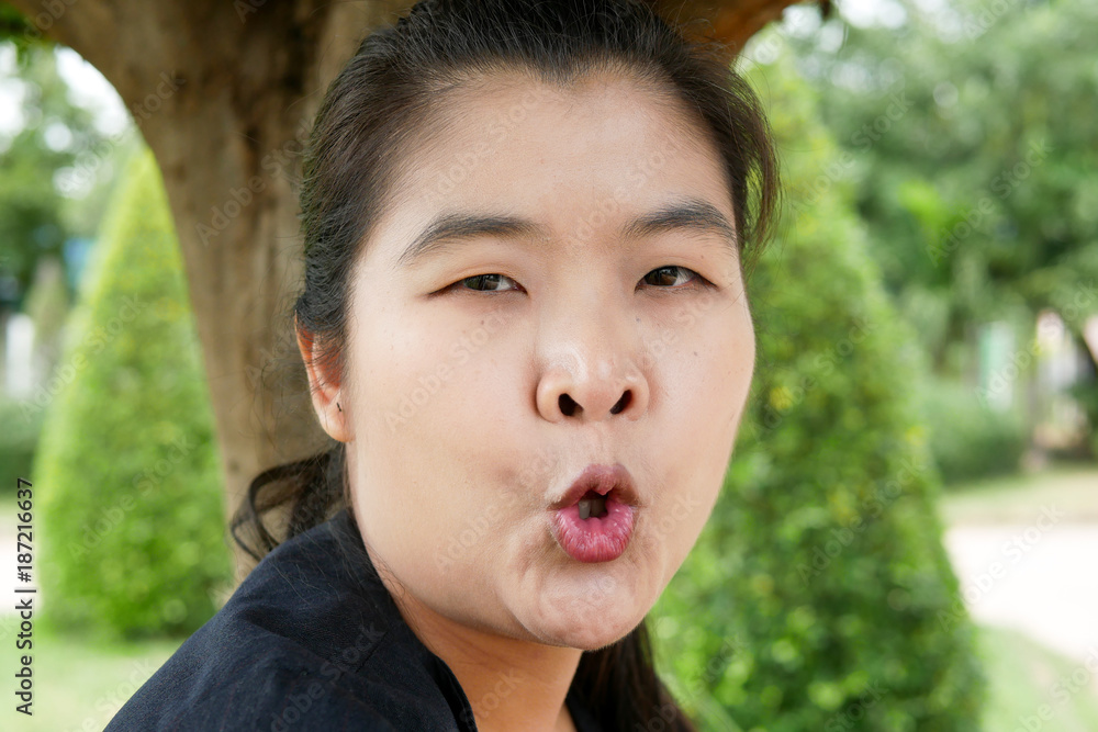 Young Asian Woman Pucker Up Her Lips in a Public Park Young Asian Woman Pucker Up Her Lips in a Public Park