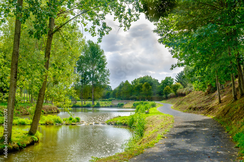 Path alongside St-Fraimbault's pond in the Orne on an overcast day in summer, Normandy France