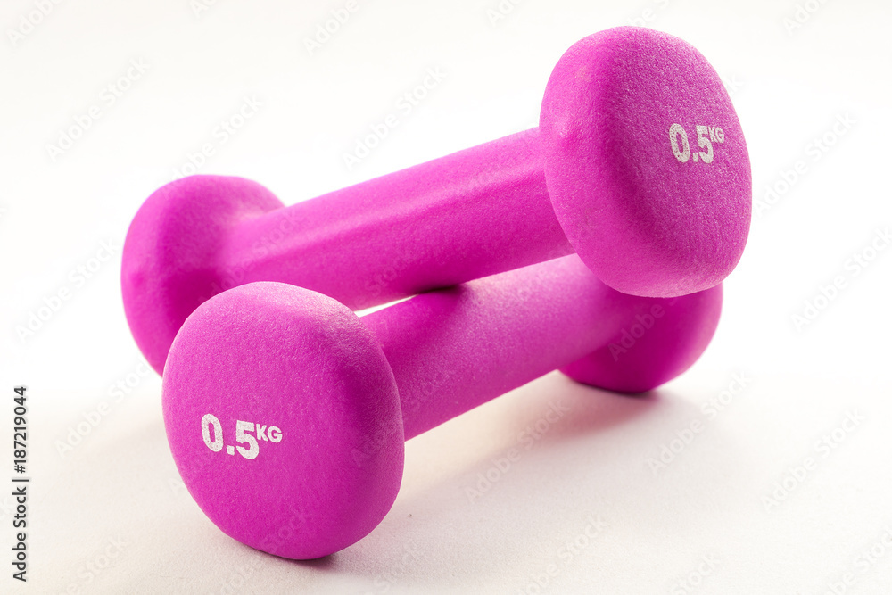 Fitness activity and the health benefits of exercising concept with light pink dumbbells isolated on white background with a clipping path included Fitness activity and the health benefits of exercising concept with light pink dumbbells isolated on white background with a clipping path included