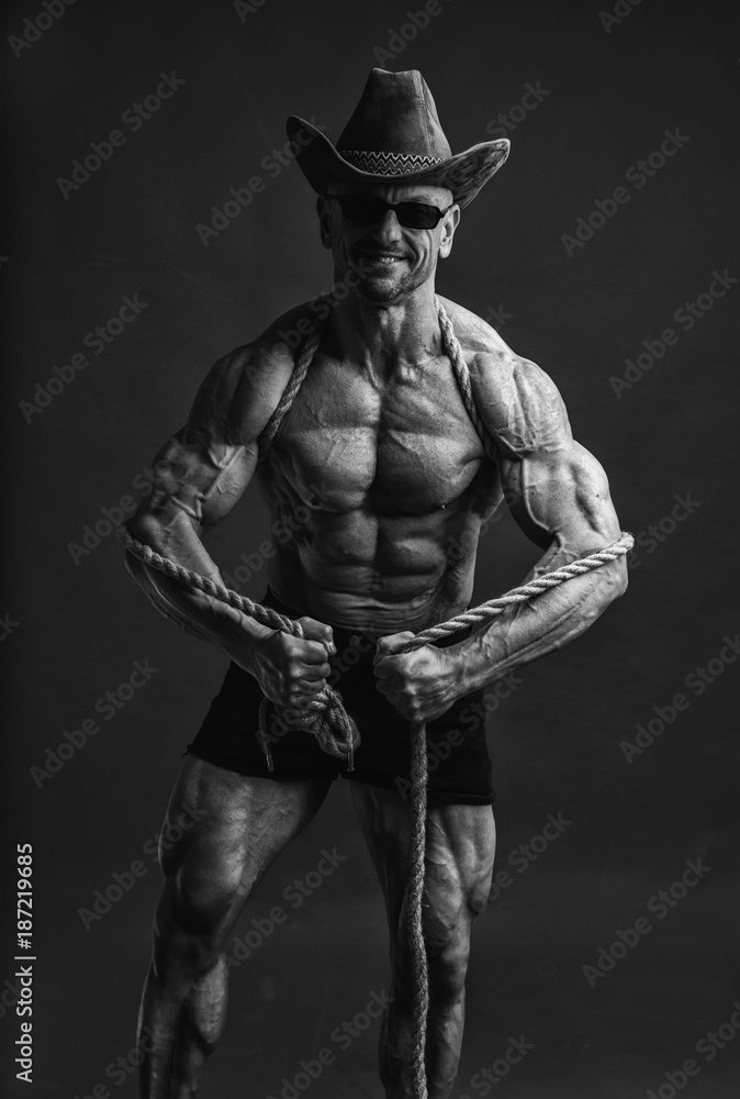 Fototapeta premium A cowboy in his hat and sunglasses with a rope on his shoulder.