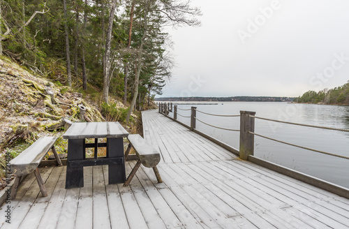 Bord och bänkar vid frostig strandpromenad ute på Värmdö photo